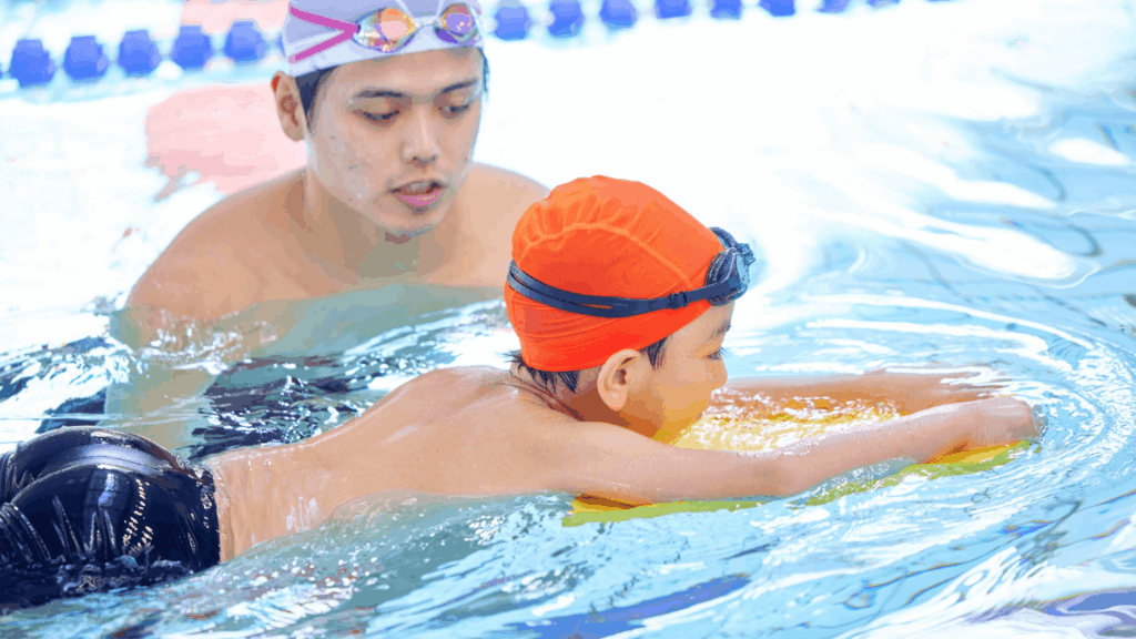 Beginner child swim training with instructor in swimming class